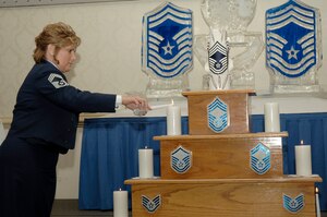 Chief Master Sgt. Tonya Blythe lights one of the nine candles during the Chiefs' Group Recognition Ceremony at the Charleston Club Feb. 7. Ten individuals were recognized after reaching the highest enlisted grade in the Air Force during the official ceremony. Chief Blythe is assigned to the 560th Rapid Engineers Deployable Heavy Operational Repair Squadron at Charleston AFB. (U.S. Air Force photo/Staff Sgt. Marie Cassetty)