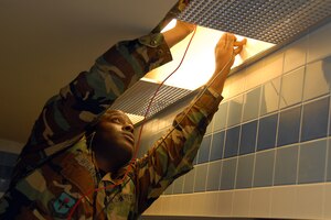 Senior Airman Ivan Williams tests the voltage for a light fixture in the Charleston Club Feb. 11. He was making sure the fixture was at 277 volts to help prevent safety mishaps. Airman Williams is an electrical systems journeyman with the 437th Civil Engineer Squadron (U.S. Air Force photo/Airman 1st Class Melissa White)