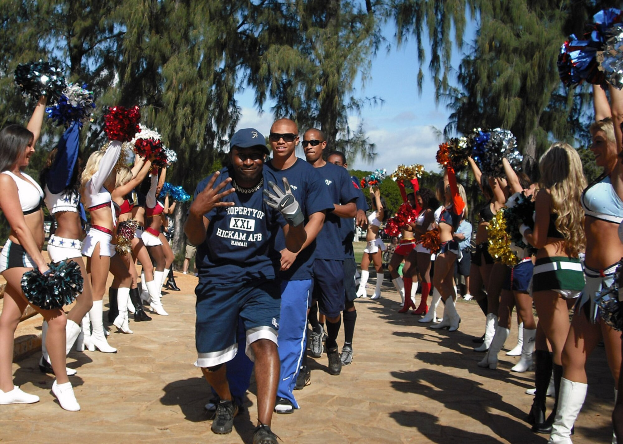 Capt. Marcus Fox leads the Air Force team through a procession of NFL cheerleaders during opening ceremonies of the NFL Military Callenge Feb. 7 in Oahu's Kapiolani Park. Captain Fox participated in the Air Force's first place finishes in the 40-yard dash, quarterback challenge and 'suicide' competitions. (U.S. Air Force photo/Mark Munsey)