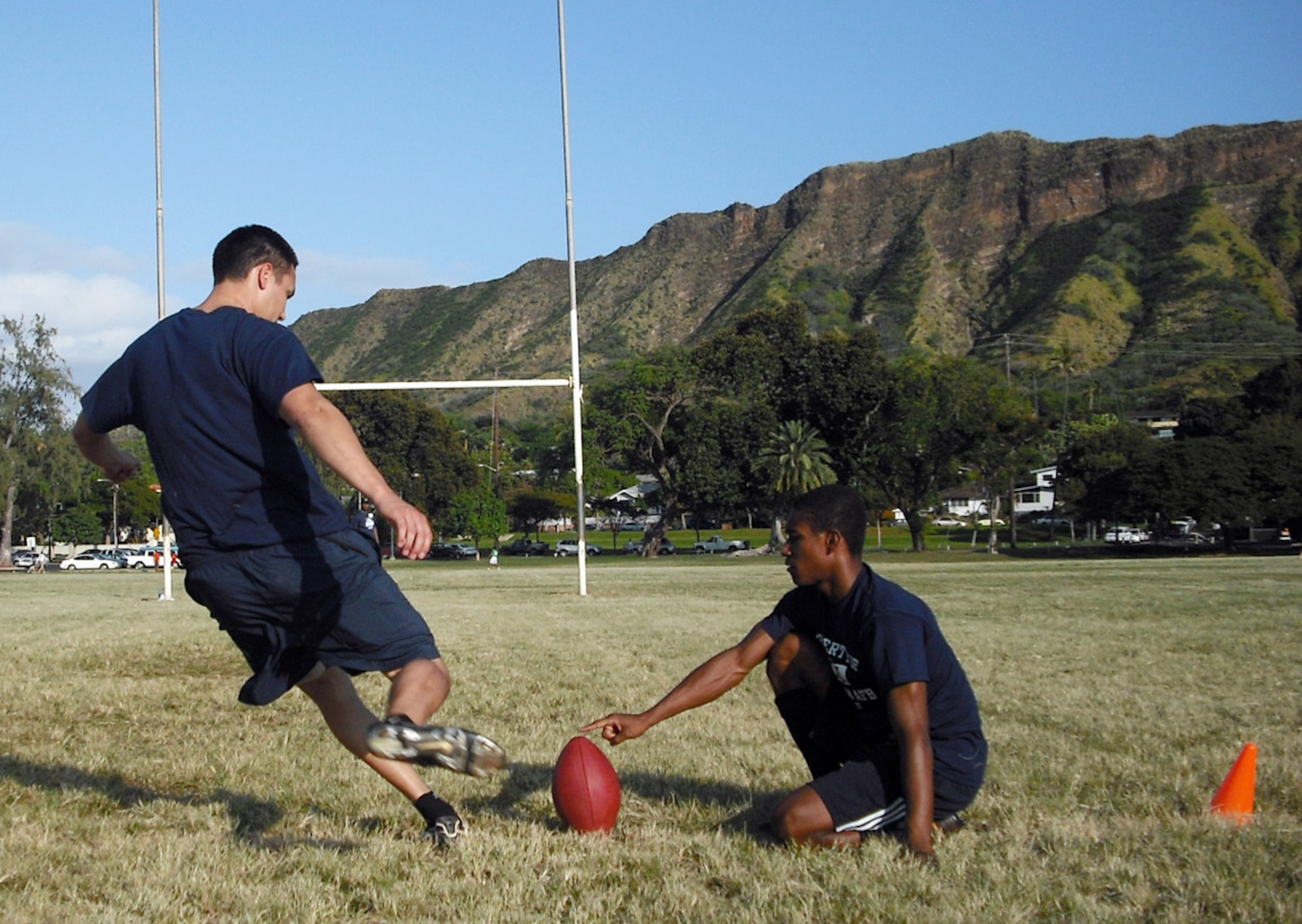 With Oahu's Diamond Head as the backdrop, 1st Lt. Mike Maynard prepares to make one of his nine field goals Feb. 7 during the NFL Military Challenge in Hawaii.  Lieutenant Maynard garnered second place in the competition, helping the Air Force win the NFL Military Challenge for the fourth consecutive year. Senior Airman Winston Jackson, who helped the Air Force capture first place in three other competitions, was the holder. (U.S. Air Force photo/Mark Munsey)