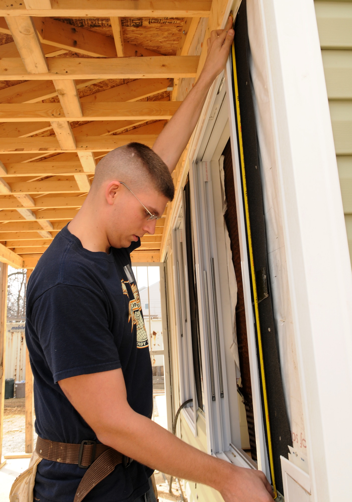 Airman 1st Class Jon P. Van Deusen, United States Air Force Honor Guard, measures an exterior wall for a piece of siding Feb. 11 during a Habitat for Humanity project in Washington D.C. The 16 Bolling volunteers worked side-by-side with trained crew members to accomplish various tasks throughout the day. (U.S. Air Force photo by Senior Airman R. Michael Longoria)
