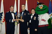 HANSCOM AIR FORCE BASE, Mass. – Lt. Gen. Ted Bowlds (left), Electronic Systems Center commander, presents Senior Airman Maurice Morrell, 66th Comptroller Squadron with the 66th Air Base Wing Airman of the Year award at the annual awards banquet on Feb. 6.  Chief Master Sgt. Karen McCoy, ESC command chief and Boston Red Sox mascot Wally the Green Monster joined in the presentation. (U.S. Air Force photo by Linda LaBonte Britt)
