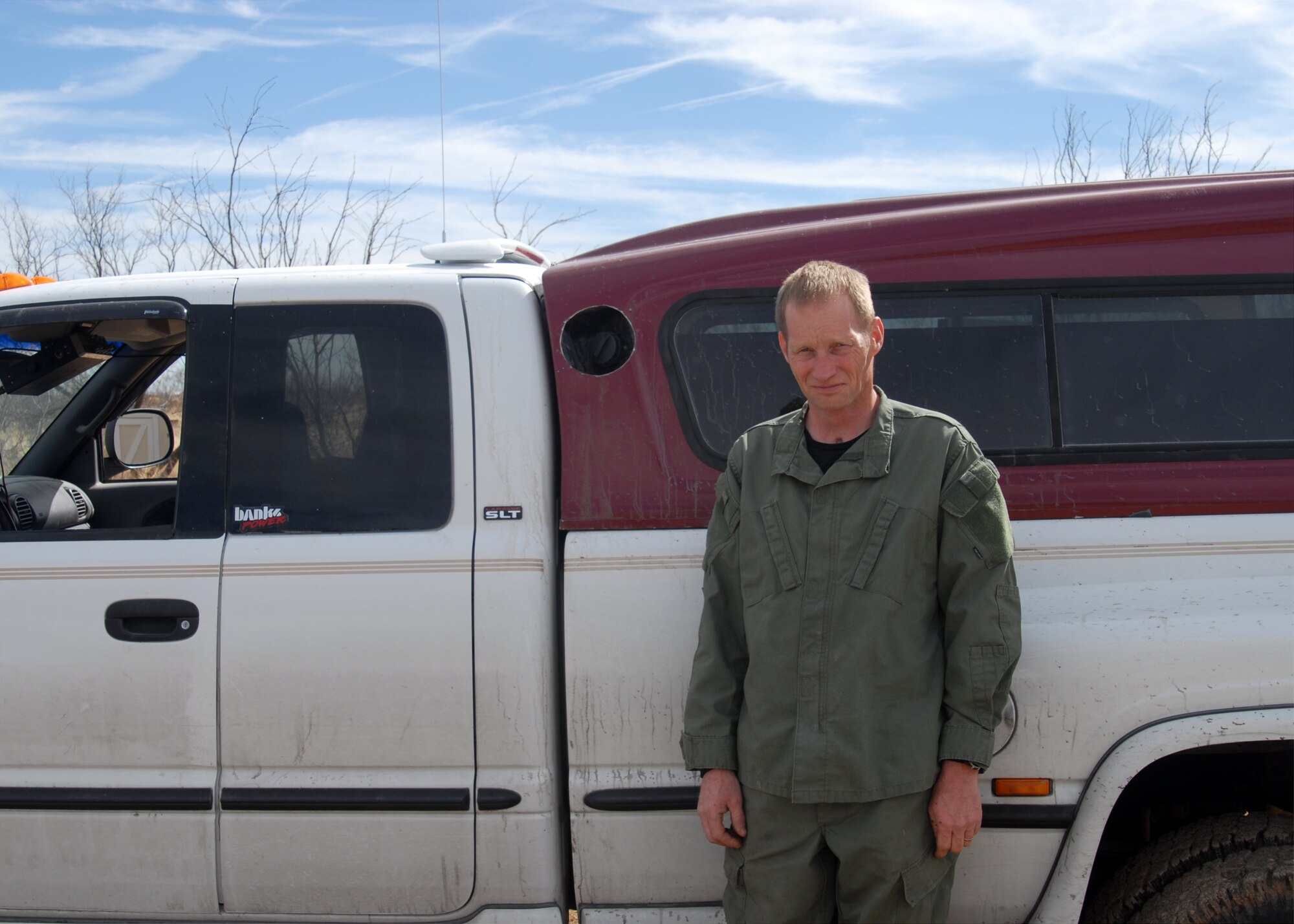 Army Staff Sgt. Roger Smith poses by his “Big Green Machine,” a truck which runs entirely on biodiesel fuel. (Editor’s note: Sergeant Smith is dressed in non-Army fatigues as part of the Opposing Force during a 344th Military Intelligence Battalion field training exercise at Camp Sentinel. U.S. Air Force photo by Senior Airman Stephen Musal)