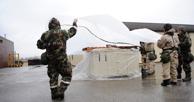 WHITEMAN AIR FORCE BASE, Mo. – Team Whiteman members cover an asset to protect it from potential chemical contamination during Ability To Survive and Operate training Feb. 11. The training provided and evaluated how well personnel use their chemical protection ensemble, how to recognize unexploded munitions and cordon off the areas to prevent other personnel from detonating the devices. (U.S. Air Force photo/Senior Airman Stephen Linch)