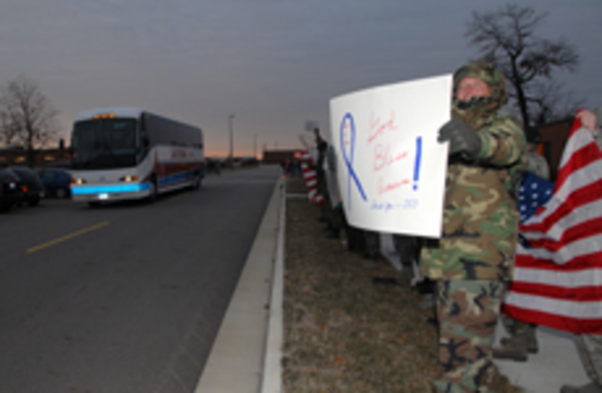 Several members of the 178th Fighter Wing stand along Regula Avenue to send off the deploying members of the Security Forces Squadron