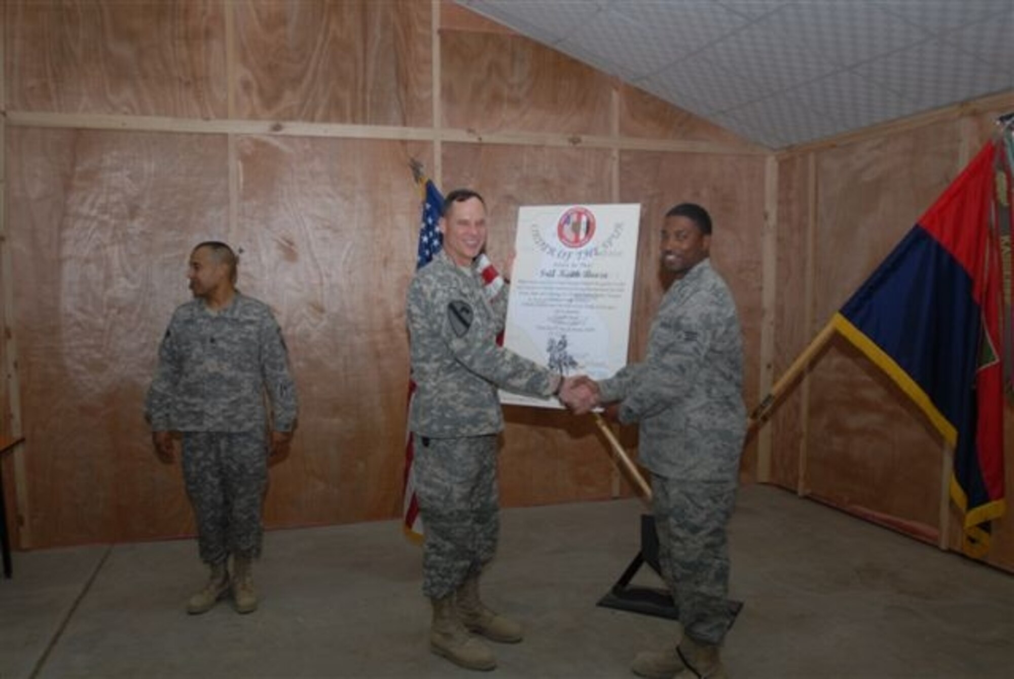 Army Brig. Gen. Keith Walker, Multi-National Corps–Iraq Assistance Group commanding general, presents Senior Airman Keith Booze, IAG personnel technician, his combat spurs Feb. 10 at Camp Victory Iraq. The Order of the Spur is an Army Cavalry tradition. Soldiers serving with Cavalry units are inducted into the Order of the Spur after successfully completing a "Spur Ride" or for having served during combat as a member of a Cavalry unit. (Courtesy photo)