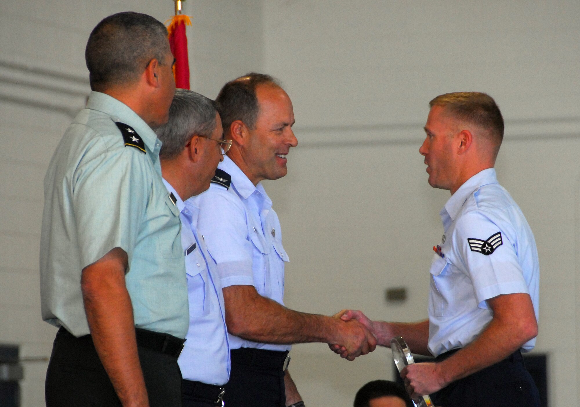 Senior Airman Brian Henry (right) is presented the 162nd Fighter Wing Airman of the Year Award Feb. 7 by Col. Greg Stroud, 162nd Fighter Wing acting commander while Maj. Gen. Hugo Salazar, Arizona Adjutant General, and Brig. Gen. Michael Colangelo, Arizona Air National Guard commander, wait to offer their congratulations. (Air National Guard photo by Master Sgt. Dave Neve)