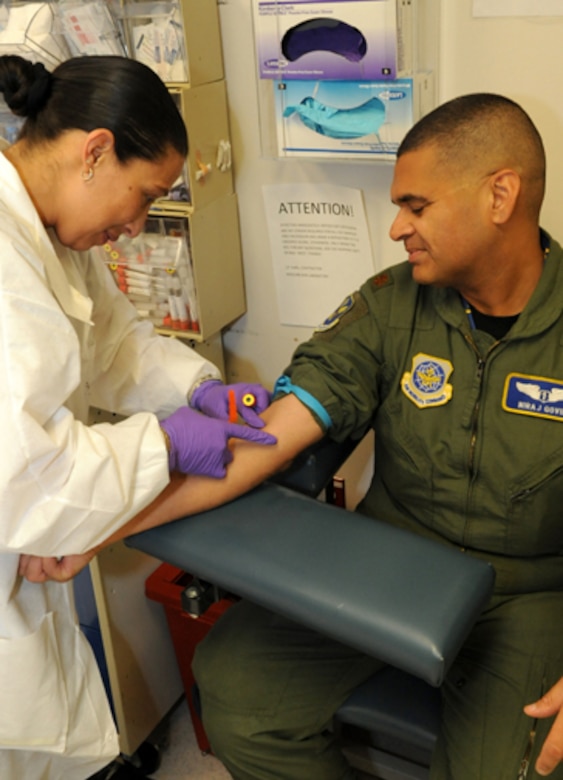 Maj. Nira Govil, chief of Aerospace Medicine with the 305th Medical Group, shows that even unit leaders have to take care of their post-deployment health survey. Major Govil, who just returned from a 10-week deployment to Al Dhafra, has his blood drawn by Nora Beljour, 305th MDG laboratory technician and recent winner of the Medical Group's “Striving to Achieve Real Success” award. The STARS award, which is customer service-based, is given to the medical personnel who exemplify the group's goal to treat "people" not just "patients". (U.S. Air Force photo/Wayne Russell)
