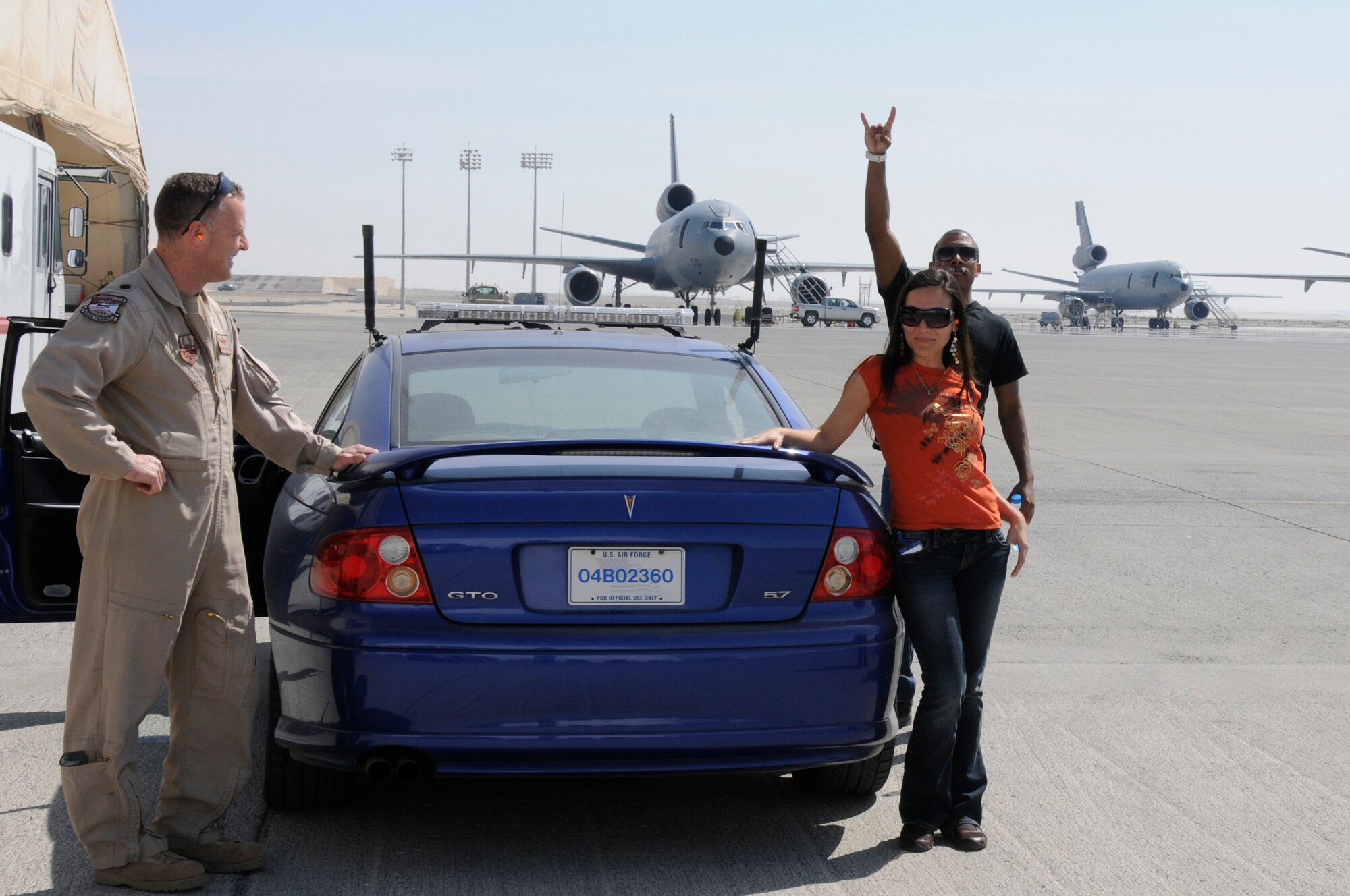 SOUTHWEST ASIA - Anita Benner, lead singer and Zeale, emcee of Los Bad Apples stop to pose for a photo before a ride in the chase car during a U-2 Dragonlady take-off at the 380th Air Expeditionary Wing, Feb 10. The band were able to get an up close tour of the aircraft and interact with Airmaen of the 380th. Los Bad Apples are a latin inspired hip-hop band on their second stop of an Armed Forces Entertainment tour. (U.S. Air Force photo by Senior Airman Brian J. Ellis) (Released)