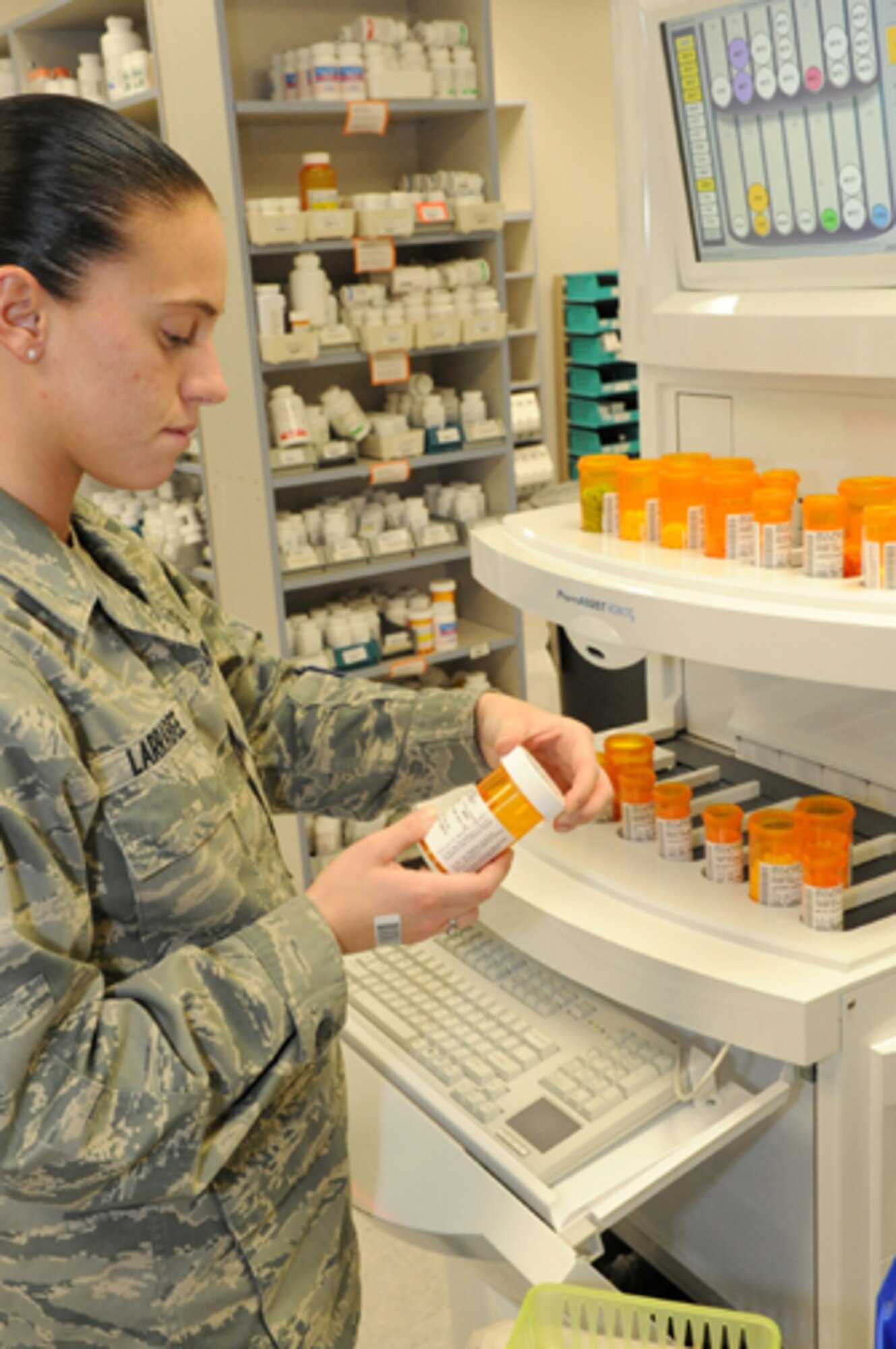 With only eight months in the Air Force, Airman 1st Class Ashley Larrabee, 305th Medical Group pharmacy apprentice, double-checks the accuracy of the PharmAssist RobotX. The PharmAssist RobotX auto-fills and labels some of the prescriptions that come through the pharmacy, but as a precaution a pharmacist or assistant verifies and caps the bottles. The RobotX is just one way that Medical Group personnel are striving to provide quality service faster. (U.S. Air Force photo/Wayne Russell)
