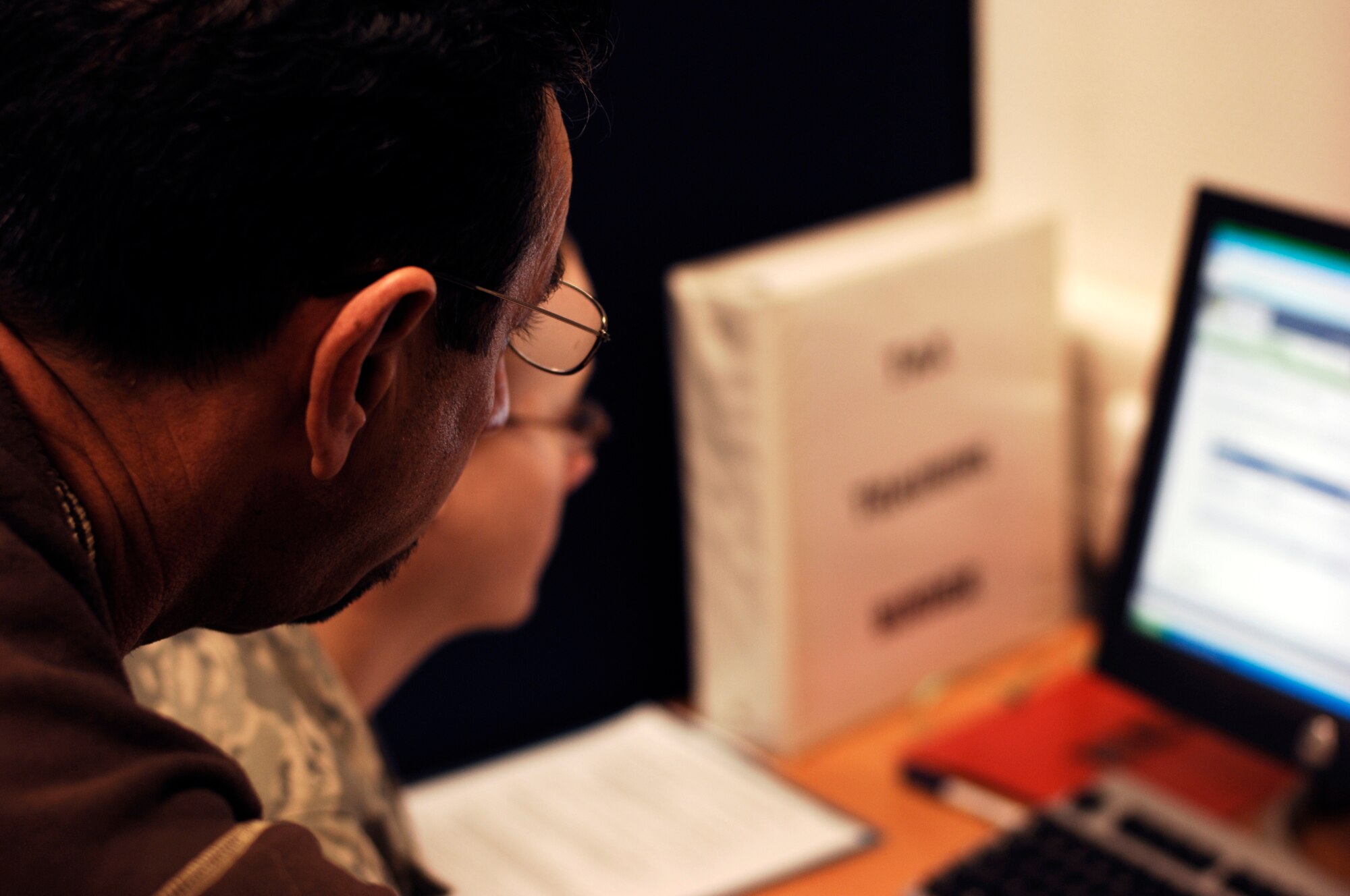 Joe Ferreyra (left) helps Staff Sgt. Katie Sawyer, 1st Combat Communication Squadron member, with her taxes Feb. 10, 2009, at Ramstein Air Base. The tax center has trained volunteers that assist customers with their taxes. (U.S. Air Force photo by Senior Airman Amber Bressler)