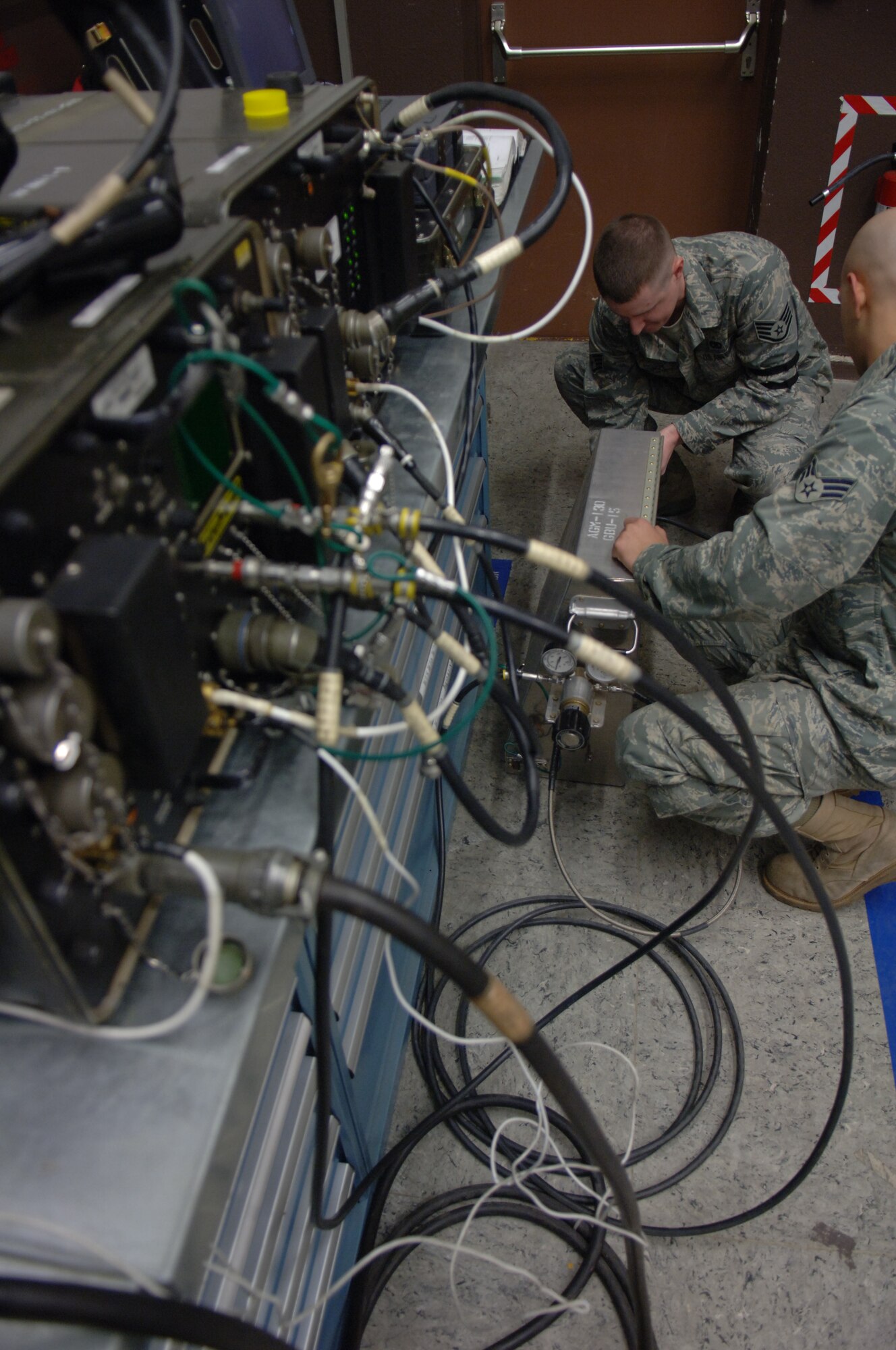 Staff Sgt. Samuel Macilroy, 435th Munitions Squadron munitions maintenance crew chief, and Senior Airman Justin Anaya, 435th Munitions Squadron munitions maintenance crew member, set up equipment to run tests on a AGM-130 missile Feb. 4, 2009, at Ramstein Air Base. (U.S. Air Force photo by Senior Airman Levi Riendeau)