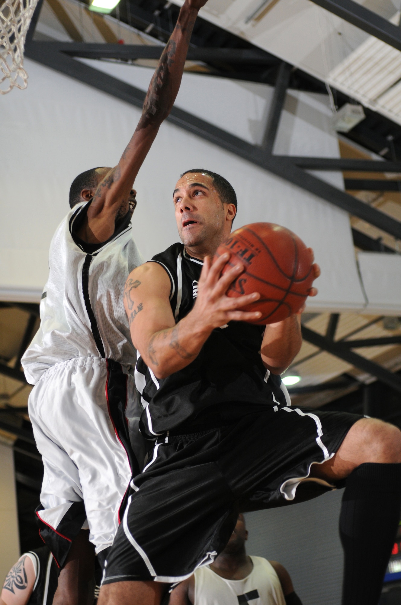 Staff Sgt. Ryan Voisin, No. 22 for the services team, goes for a lay-up during the 30-and-under championship game against the communications squadron team Jan. 5, 2009, at Ramstein Air Base Services won with a score of 67-61. (U.S. Air Force photo by Senior Airman Nathan Lipscomb)