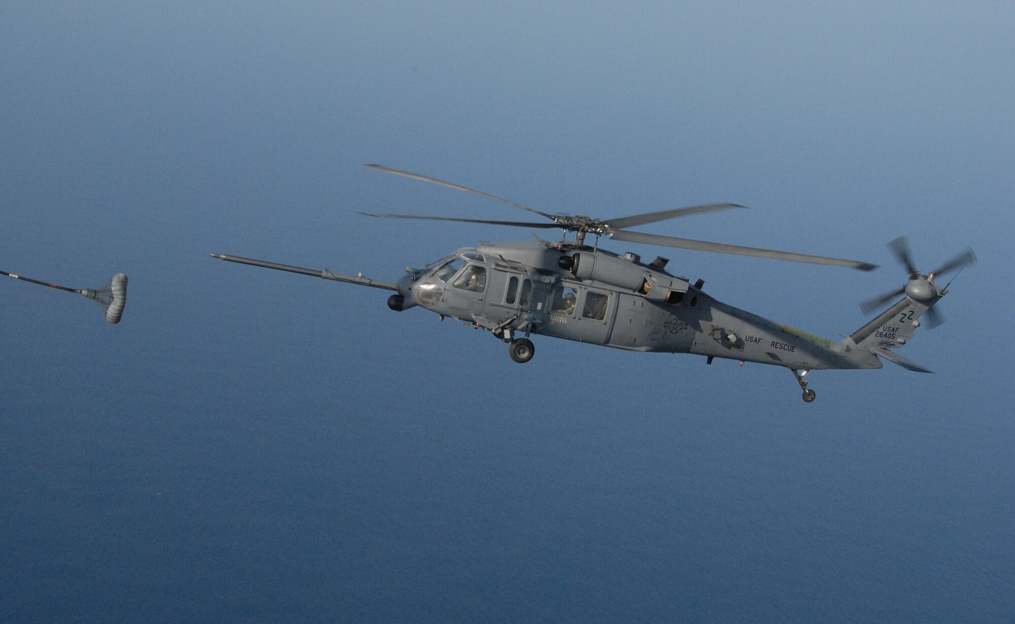 An HH-60 Pave Hawk lines ups with the C-130 drogue during an air refueling mission off the coast of Okinawa, Japan as part of exercise Cope Angel 09-1. Cope Angel is a joint rescue exercise between members of the U.S. Air Force and the Japanese Air Self Defense Force. (U.S. Air Force photo/Staff Sgt Chrissy Best)