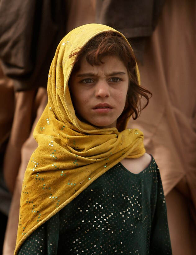 An Afghan girl wears a gold headscarf and green dress fleck with sequins, Feb. 9, 2009. 