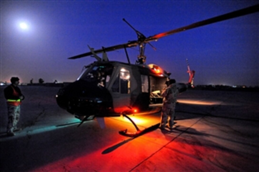 Ground and flight crews of the Iraqi Air Force's 2nd Squadron conduct final checks under moonlight in preparation for their first night vision goggle certification flight with the help of the U.S. Air Force, 721st Air Expedition Advisory Squadron, Multinational Division Baghdad, on Camp Taji, Iraq, Feb. 8, 2009.