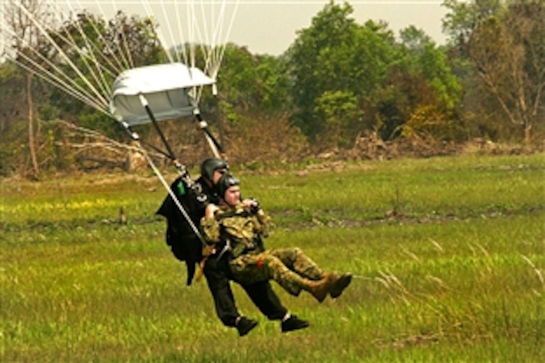 U.S. Marine Gunnery Sgt. Jeffrey Schultz, a tandem jumpmaster, and 1st Lt. Colin A. Graham are about to touch down after completing a tandem jump during Exercise Cobra Gold 09, Feb. 8, 2009. Cobra Gold is a joint, coalition multinational exercise focused on maintaining and improving military interoperability. Schultz is assigned to the Training and Education Command in Quantico, Va., and Graham is air delivery detachment officer in charge assigned to Combat Logistics Regiment 3.