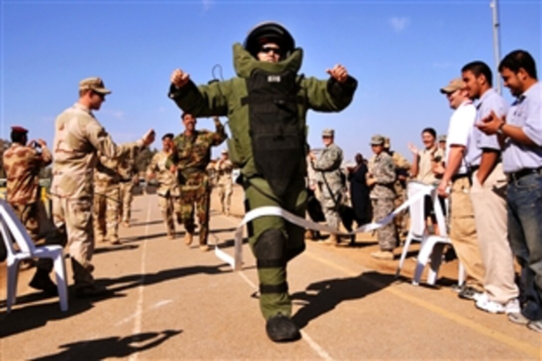 U.S. Navy Lt. Jonathan Kehoe crosses the finish line in 10 minutes and 13 seconds for the
Guinness World Record for the fastest mile in a bomb suit on Camp Echo, Iraq,
Feb. 2, 2009. Kehoe, a 63rd Battalion Explosive Ordnance Disposal commander, is assigned to the 4th Infantry Division's 2nd Brigade Combat Team.