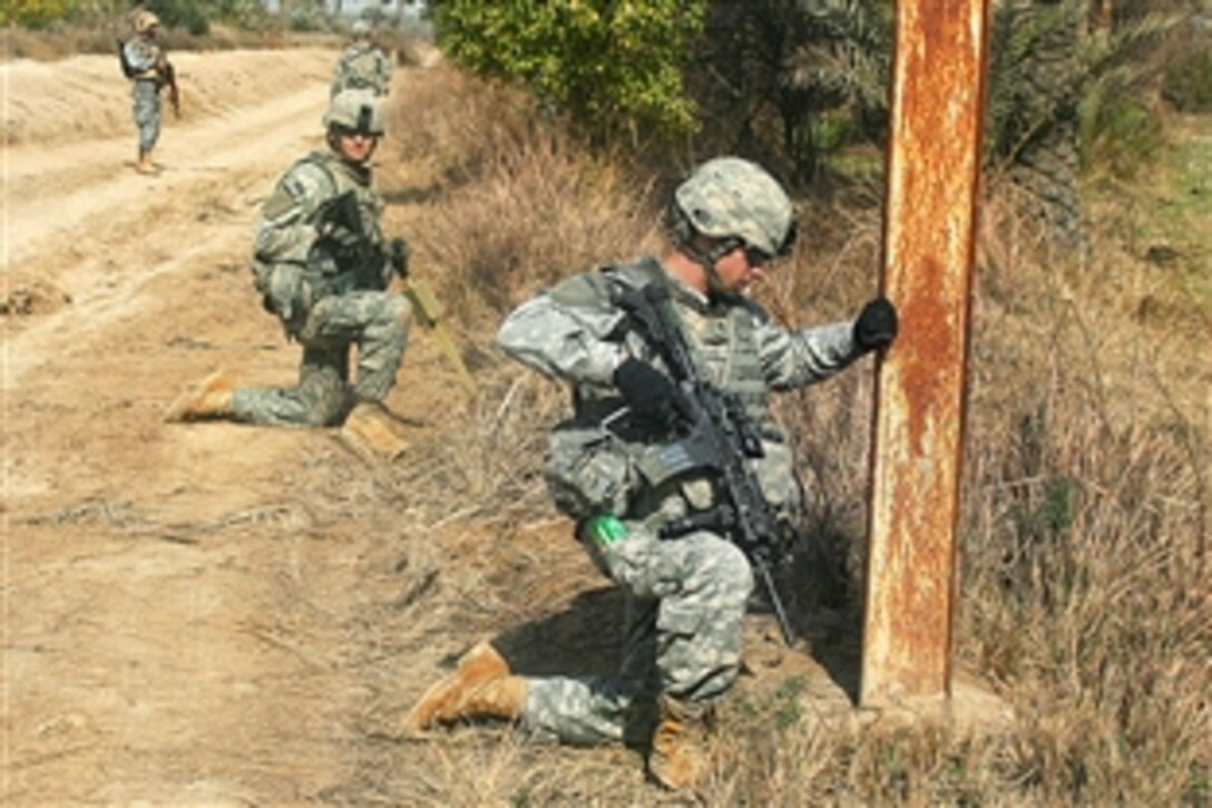 U.S. Army Sgt. George Davis, foreground, maintains security during a cache operation with Iraqi police officers in Rashidiyah Nahia, northwest of Baghdad, Iraq, Feb. 7, 2009. Davis is assigned to Company B, 52nd Infantry Regiment, attached to the 82nd Airborne Division's 1st Battalion, 27th Regiment.
