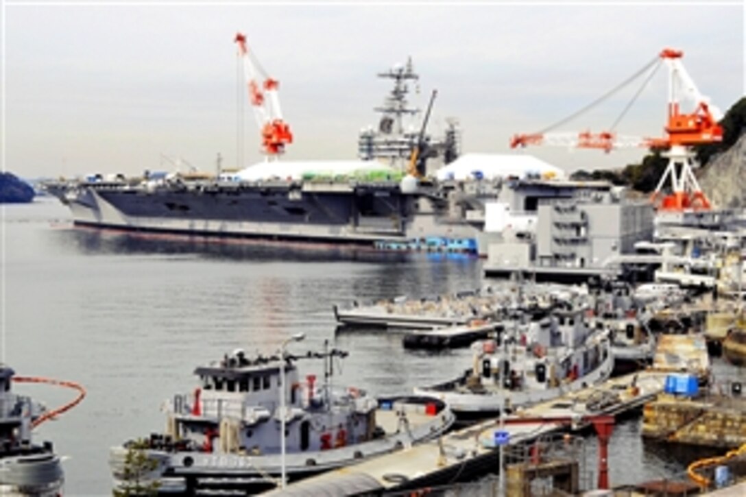 Flight deck structures aboard USS George Washington are enshrouded by cranes and tarpaulins as the carrier continues its period of restricted availability for maintenance at Fleet Activities Yokosuka, Japan, Feb. 9, 2009.