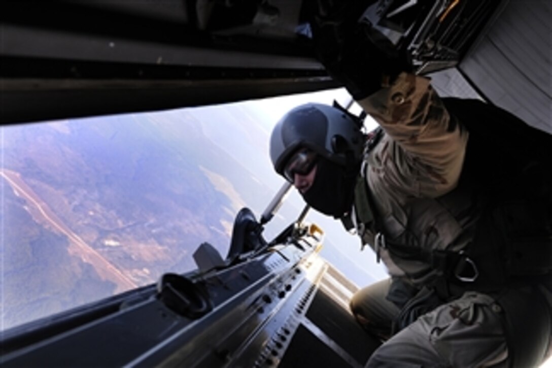 A U.S. Air Force service member riding in a C-130 Hercules turboprop aircraft identifies the drop zone before taking a high-altitude, low-opening parachute jump during exercise Emerald Warrior at Hurlburt Field, Eglin Air Force Base, Fla. on Feb. 4, 2009.  