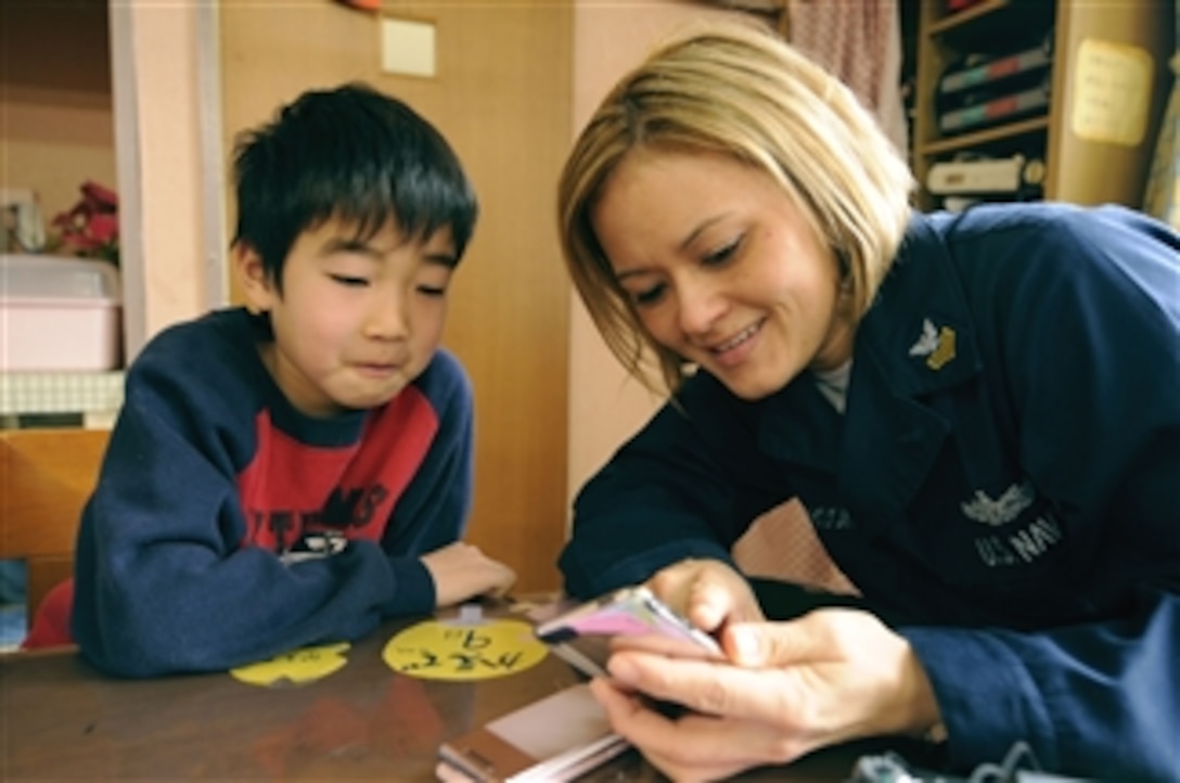 U.S. Navy Petty Officer 1st Class Christine Anderson shows her MP3 player to an orphan at the Myojoo-en Children's Home in Nagasaki, Japan, during a community service project on Feb. 7, 2009.  The USS Blue Ridge (LCC 19) sailors spent time at Myojoo-en with the children, playing games and sharing laughs.  The Blue Ridge is the flagship for Commander, U.S. 7th Fleet.  