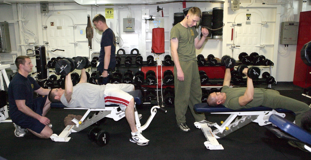 Petty Officer 3rd Class Calvin D. Brooks (left), a Gunner's mate with USS Bataan, and Lance Cpl. Ngan Nguyen (right), a combat engineer with Headquarters and Service Company, Battalion Landing Team, 3rd Battalion, 2nd Marine Regiment, 22nd Marine Expeditionary Unit, lift weights aboard Bataan during Composite Training Unit Exercise Feb. 11, 2009. The COMPTUEX is part of the MEU's pre-deployment training program. The 22nd MEU is scheduled to deploy this spring. (Official Marine Corps photo by Cpl. Theodore W. Ritchie)