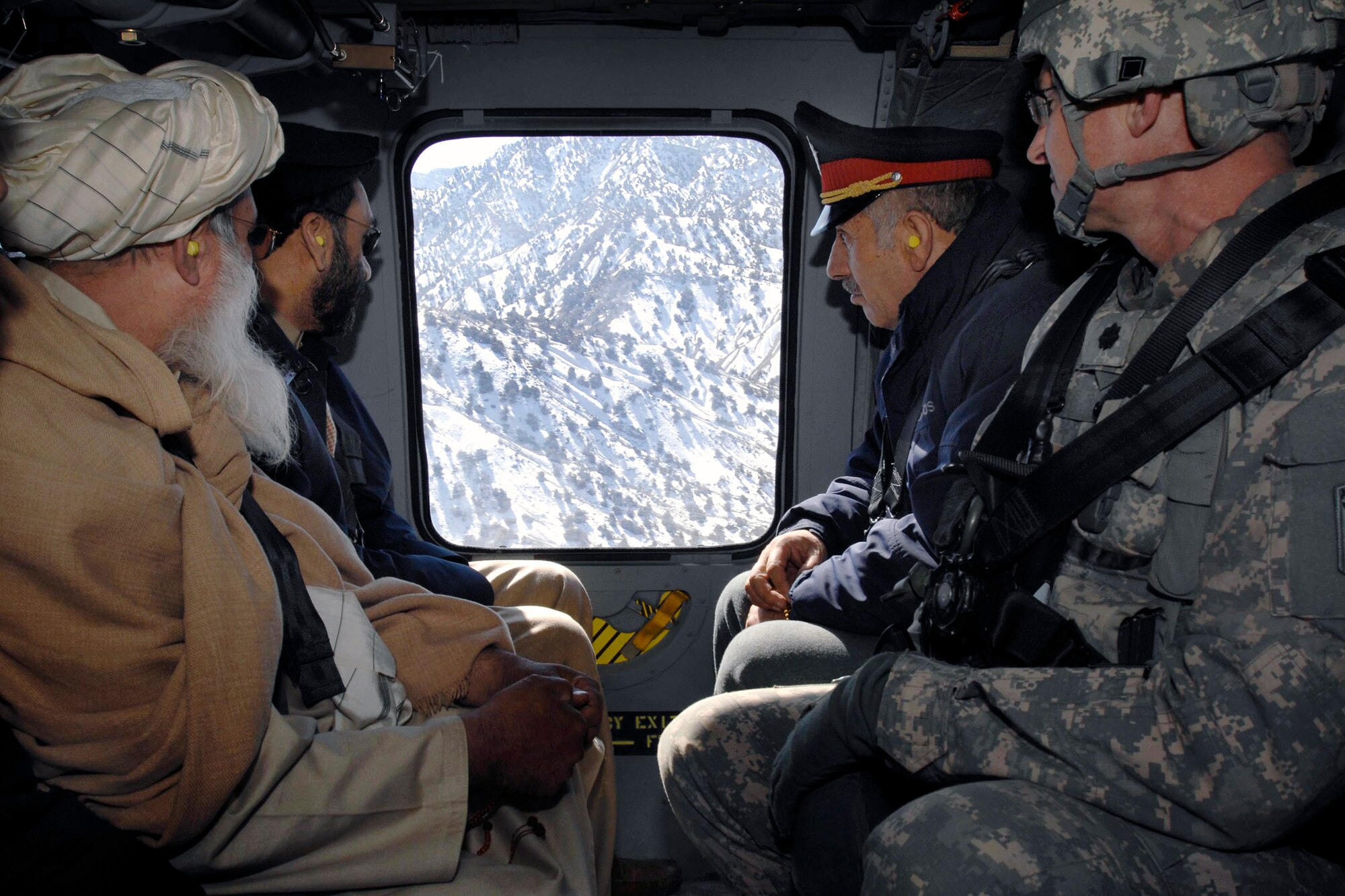 Lt. Col. Dan Moy, far right, commander for Afghanistan's Paktia Provincial Reconstruction Team, travels by helicopter to a remote combat outpost Feb. 8 with the provincial governor, police chief and a religious leader for a meeting with district leaders.  (Defense Department photo/Fred W. Baker III)    
