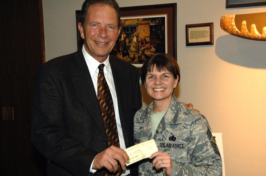 OFFUTT AIR FORCE BASE, Neb. -- John Hansen, president of the Offutt Advisory Council, presents a check for $8,000 to Chief Master Sgt. Lisa Sirois, 55th Wing command chief master sergeant.  Chief Sirois accepted the check on behalf of the Offutt Chief?s Group.   Each year, the OAC hosts a Harvest Ball fundraiser with proceeds donated to the chief?s group for the benefit of all base personnel.   The Offutt Advisory Council was established in 1992 to educate the community about the mission and needs of organizations at Offutt, especially the 55th WG; to promote the morale, welfare and education of Offutt personnel and their families; and to enhance and improve facilities and assets on Offutt.  The biggest event hosted by the OAC is the annual Offutt Appreciation Day picnic, set for June 5 this year.  The organization has about 200 members from the local community including bankers, real estate agents, doctors and small business owners.  U.S. Air Force Photo By: Dana Heard