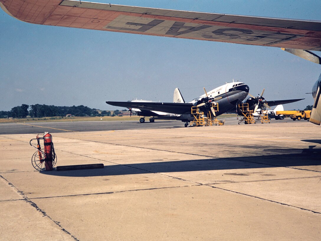 A maintenance crew of the 140th Aeromedical Transport Group Pennsylvania Air National Guard works on the engines of this C-46 Commando at Spaatz Field Reading, Pa.  March, 1985.  Affectionately called "the Jug", the C-46 was the first prop engine aircraft of the 140th AMS.