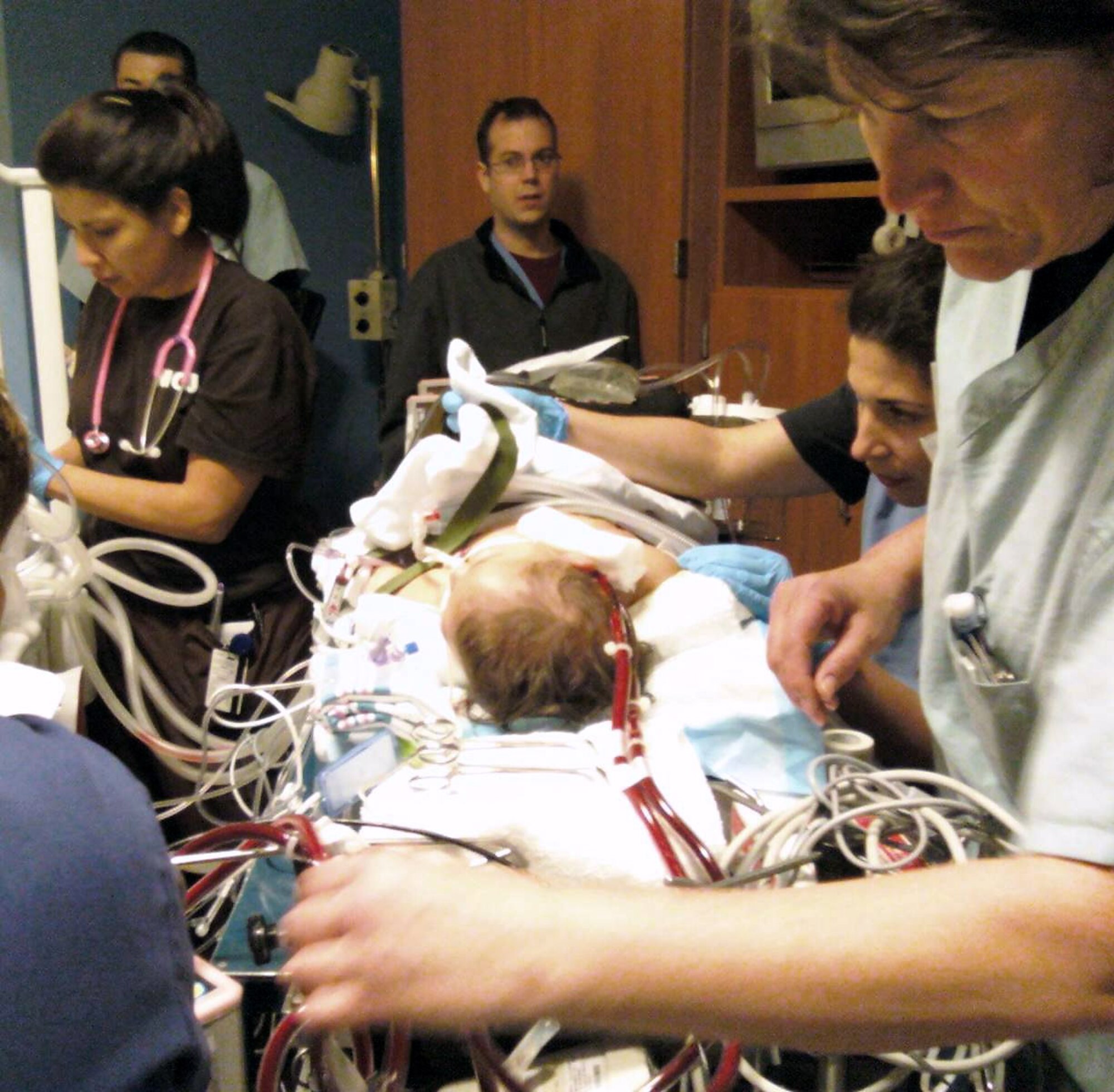 Medical personnel from Wilford Hall Medical Center, Lackland Air Force Base, Texas, and Scott and White Hospital move an 8-month-old child onto a portable extracorporeal membrane oxygenation transport cart as they prepare to move the child from the Temple, Texas, hospital to a hospital in San Antonio. The Air Force team put the critically-ill baby on ECMO, a heart-lung bypass machine, on Feb. 9 to save her life. (U.S. Air Force photo) 