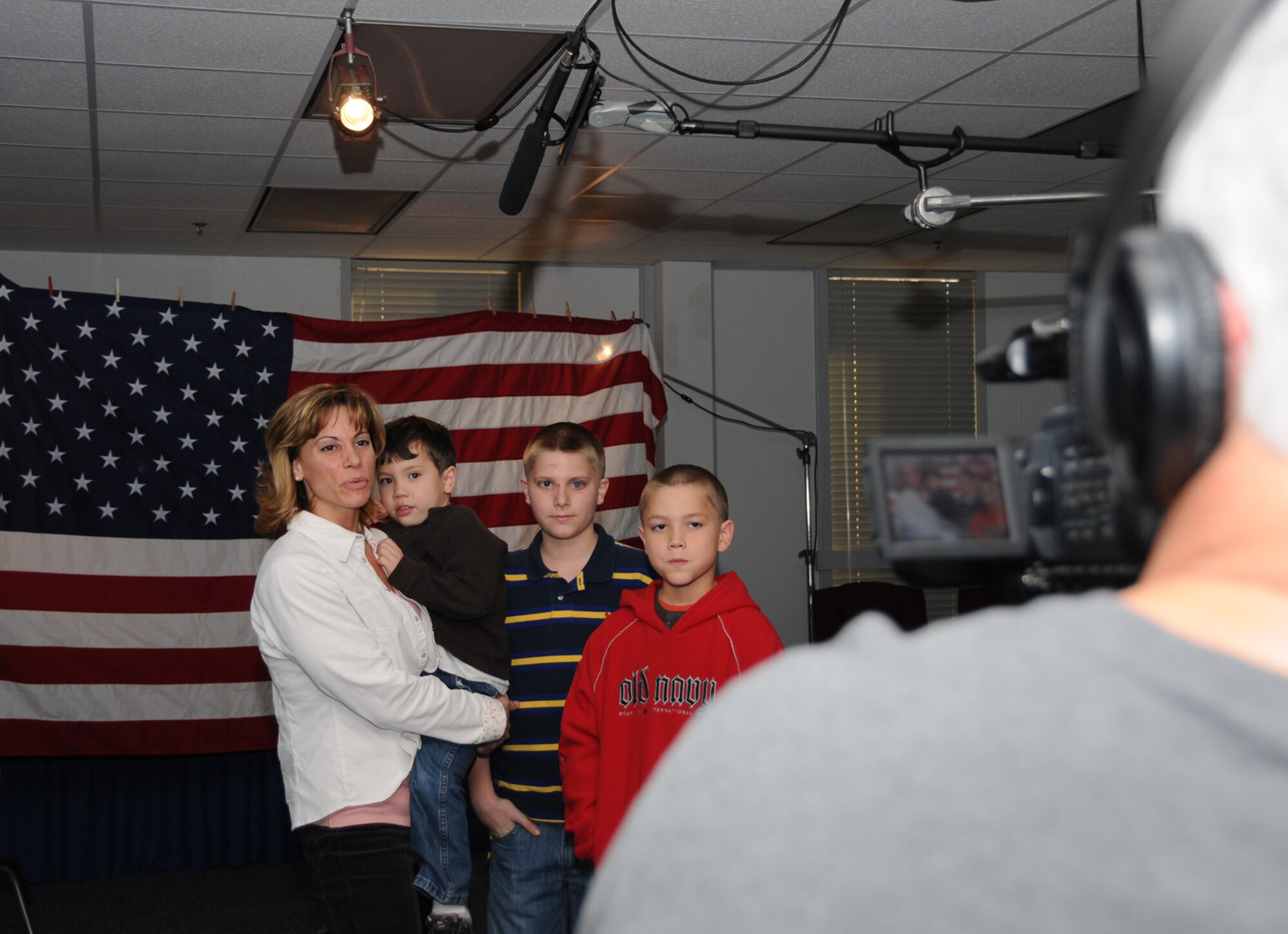From left, Lisa Stewart and her sons, Caleb Stewart, 4; Ramsey Raines, 12; and Mason Raines, 9, film a greeting for Tech. Sgt. Roger Stewart, 81st Logistics Readiness Squadron, who’s deployed to Kyrgyzstan.  WLOX-TV cameraman Mike Filippi came to Sablich Center Feb. 3 to tape segments to air on the station and post on the its Web site as part of its Troop Salute program.  (U.S. Air Force photo by Kemberly Groue)