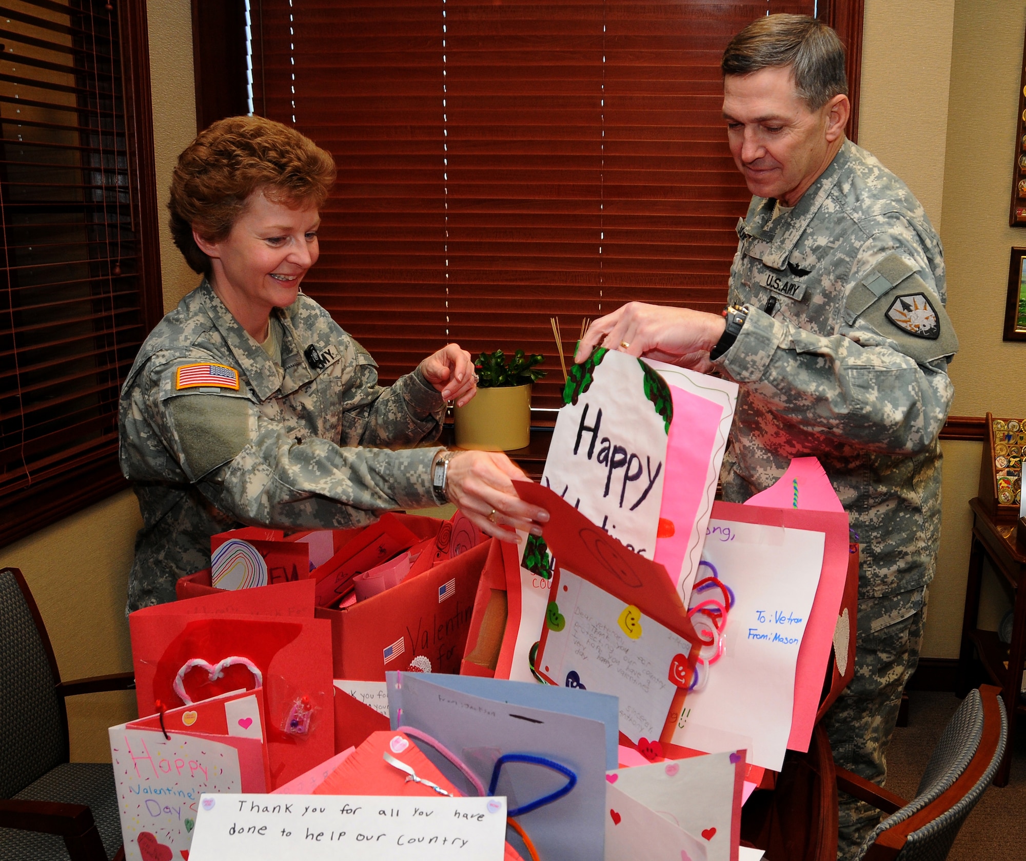 SCOTT AIR FORCE BASE, Ill. -- Lt. Col. Katherine Hipp, U. S. Transportation Command Inspector General's office, shows Maj. Gen. William Johnson, USTRANSCOM chief of staff, a group of valentines destined for Army troops in Afghanistan. Hipp's daughter, Elena, arranged for her classmates to provide the valentines. (Photo courtesy Bob Fehringer) 