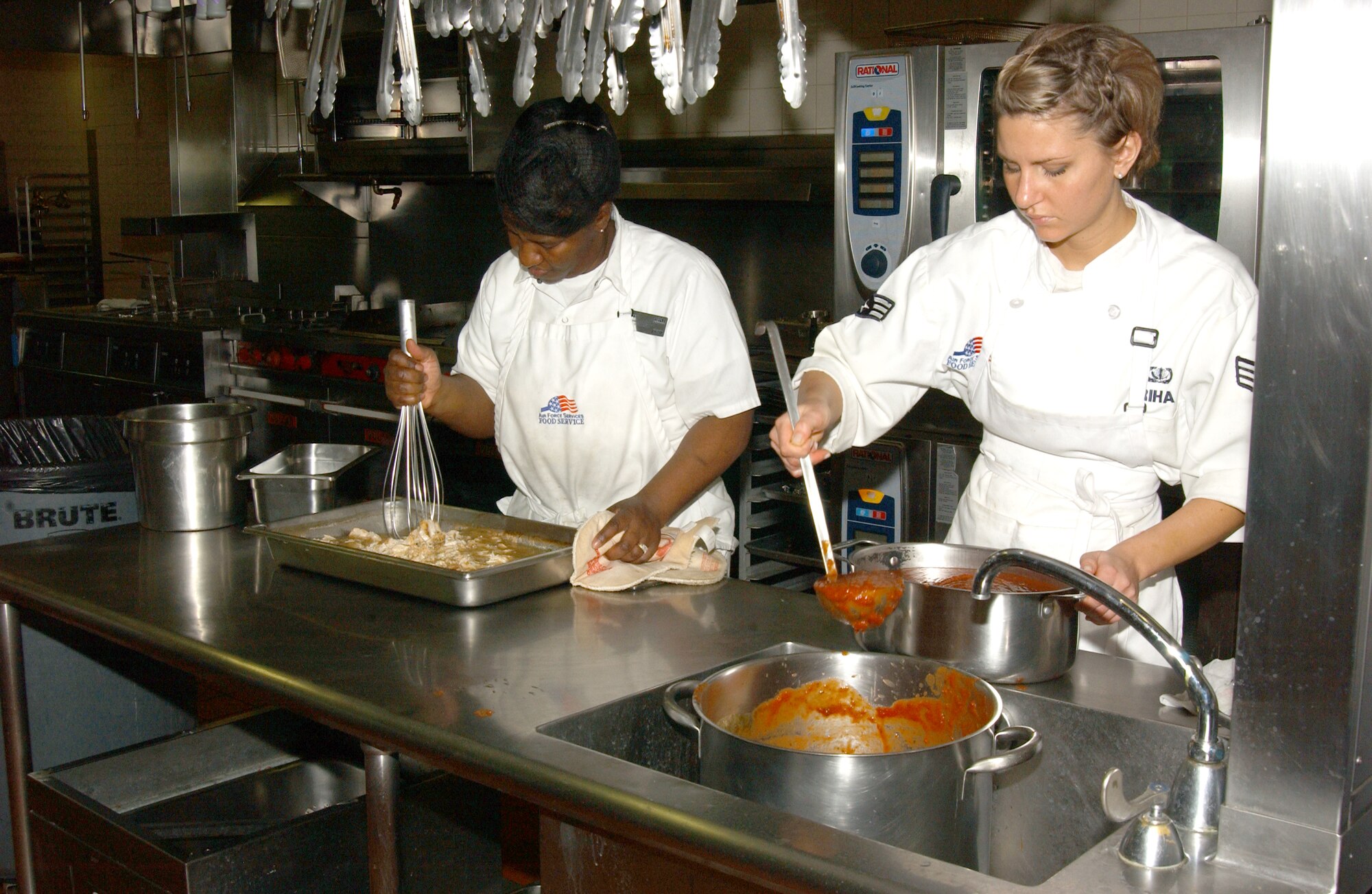 SCOTT AIR FORCE BASE, Ill. -- Angie Stevenson and Senior Airman Jessica Riha, both from the 375th Services Squadron, work together to prepare lunch at Nightingale Inn Dining Facility. (U.S. Air Force photo/Airman 1st Class Amber Kelly-Woodward)