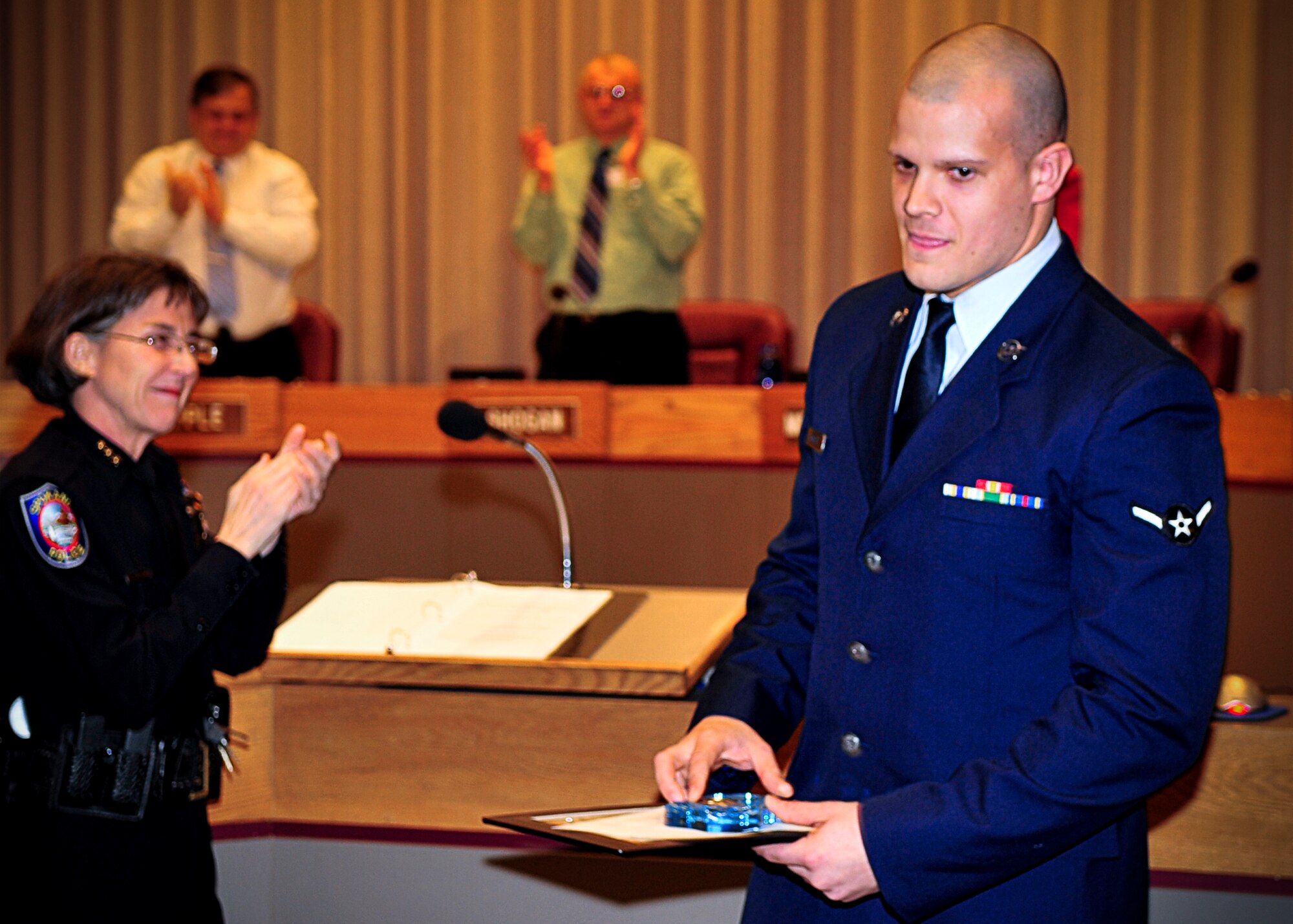 Airman David Scarlett, 66th Training Squadron survival, evasion, resistance and escape student, steps away from the podium at the Spokane City Hall after being presented with a Citizen Life Saving medal from the Spokane City Chief of Police, Anne Kirkpatrick, for a heroic act that resulted in two saved lives Feb. 9. (U.S. Air Force photo / Senior Airman Joshua K. Chapman)