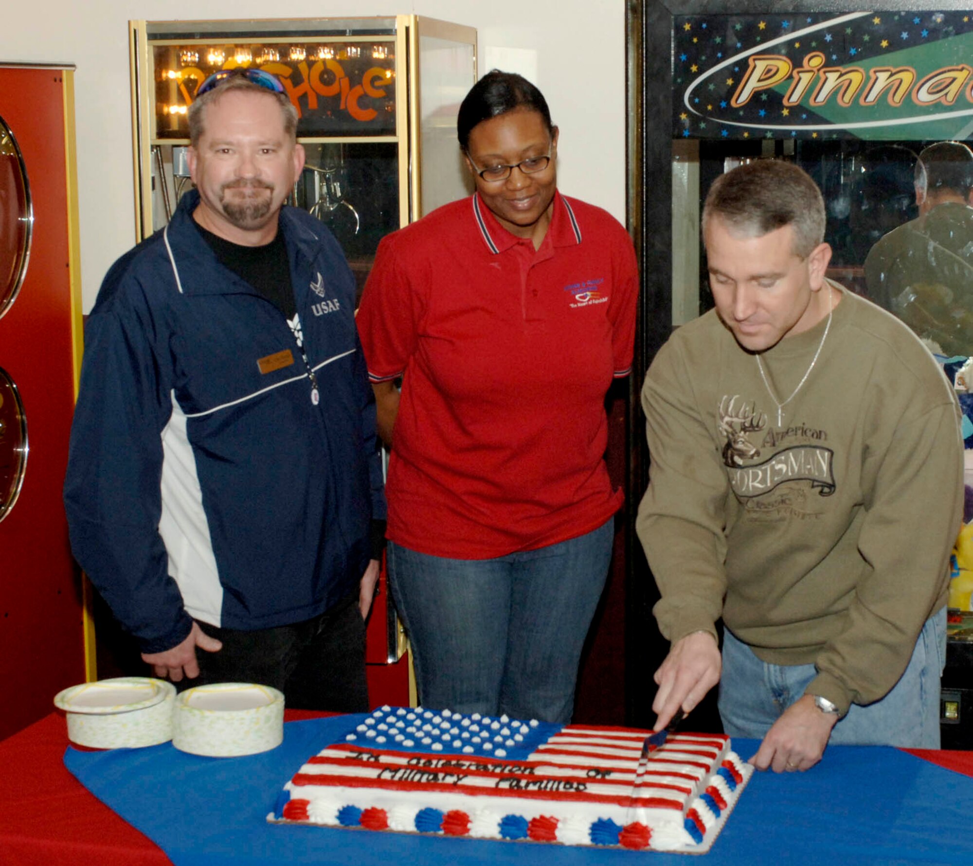 Major Jason Knight, 92nd Force Support Squadron commander, cuts the cake at the FunSpot during Operation Home Front Feb 7. Operation Home Front is project full of activities and information for families dealing with deployment.  Some of the services offered are military and family consultants through the Airman and Family Readiness Center, American Red Cross, Balfour Beatty military housing, Operation Pillowcase sponsored by Operation Spokane Heroes, and Operation Book Read. (U.S. Air Force photo / Airman 1st Class Darlene West)