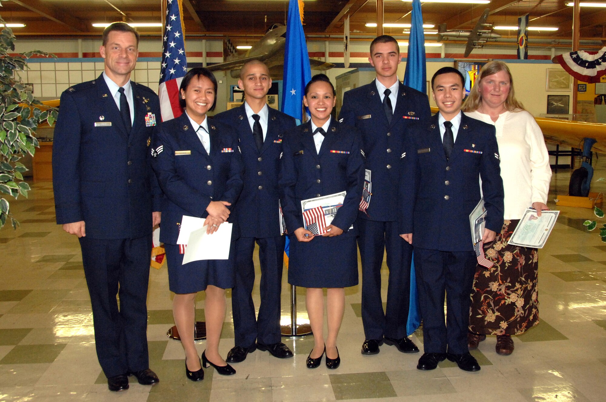 Team Travis' newest American citizens have their photo taken with Col. Mark Dillon, 60th Air Mobility Wing commander, following their naturalization cermony at the Travis Air Museum Feb. 6. From left to right are Senior Airman Krisitine Spence, 60th Medical Support Squadron, Airman 1st Class Juan Hernandez, 60th Aerial Port Squadron, Airman 1st Class Vicky Santon, 60th Diagnostics and Therapeutic Squadron, Airman 1st Class Alphonso Pelayo, 60th Logistics Readiness Squadron, Airman 1st Class Elbi Ballesteros, 60th Surgical Operations Squadron and Susan Benjamin, a military spouse.   (U.S. Air Force photo by Civ/Nan Wylie) 