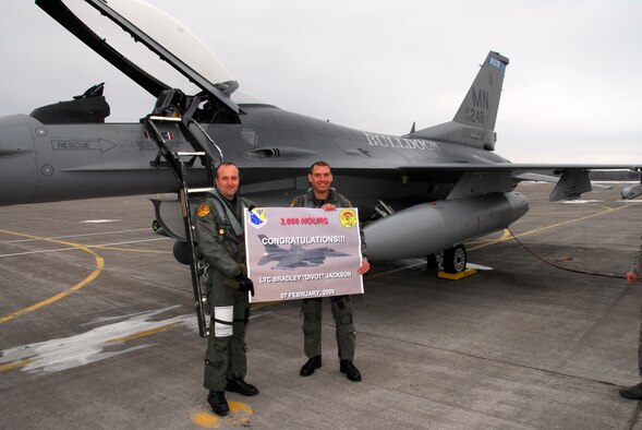 Lt. Col Reed Bowman presents a sign to his wingman, Lt. Col Brad Jackson, for surpassing 3000 Flight Hours in his F-16 on February 7, 2009 in Duluth, Mn at the 148th Fighter Wing.  On February 7 2009, Lt. Col Jackson became the first pilot, from the 148th FW, to go over 3000 flight hours in an F-16.