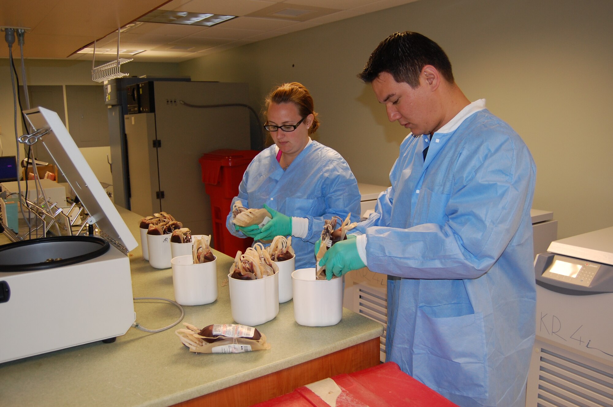 Medical laboratory technicians Stacey Foster, left, and Robert Moody process freshly-donated blood for shipment to Southwest Asia at the donor center.  (U.S. Air Force photo by Steve Pivnick)