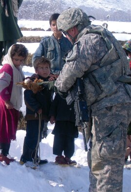 Master Sgt. James Mogren, who just won Senior Non-Commissioned Officer of the Month for the 755th Air Expeditionary Group, tries to make a connection with Afghan children by using a teddy bear. In peacetime and in war, Civil Affairs units bridge the gap between coalition forces and the local population by providing necessities and attempting to improve the quality of life. (Air Force photo)