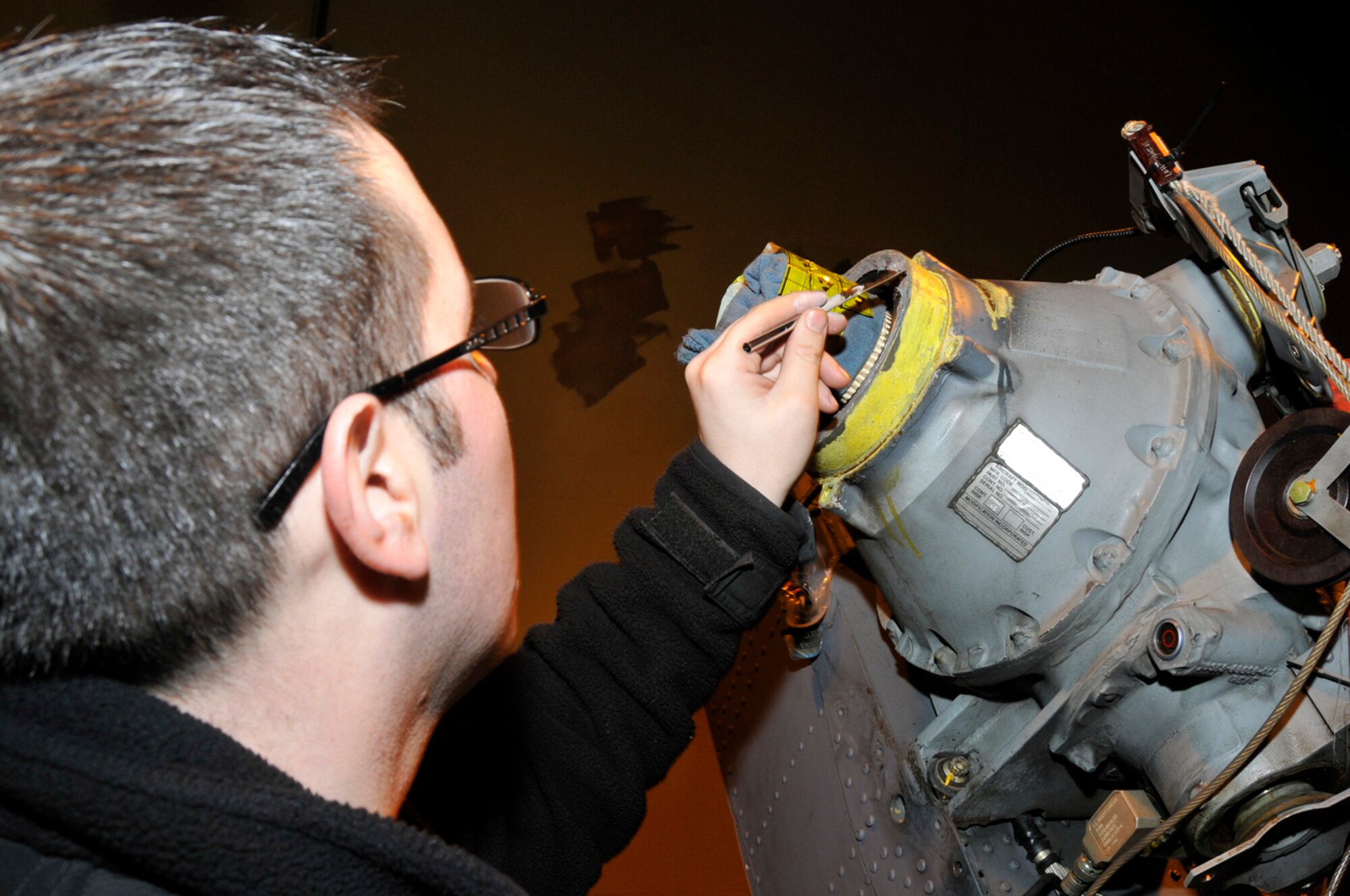 Staff Sgt. Seth Nehiley, 56 Aircraft Maintenance unit crew chief, uses a two-part sealant to seal the tail gear box's output seal, Jan. 27 at RAF Lakenheath, England. The sealant will help keep the fluid inside the gear box to prevent it from burning up when in flight. (U.S. Air Force photo by Airman 1st Class Perry Aston)