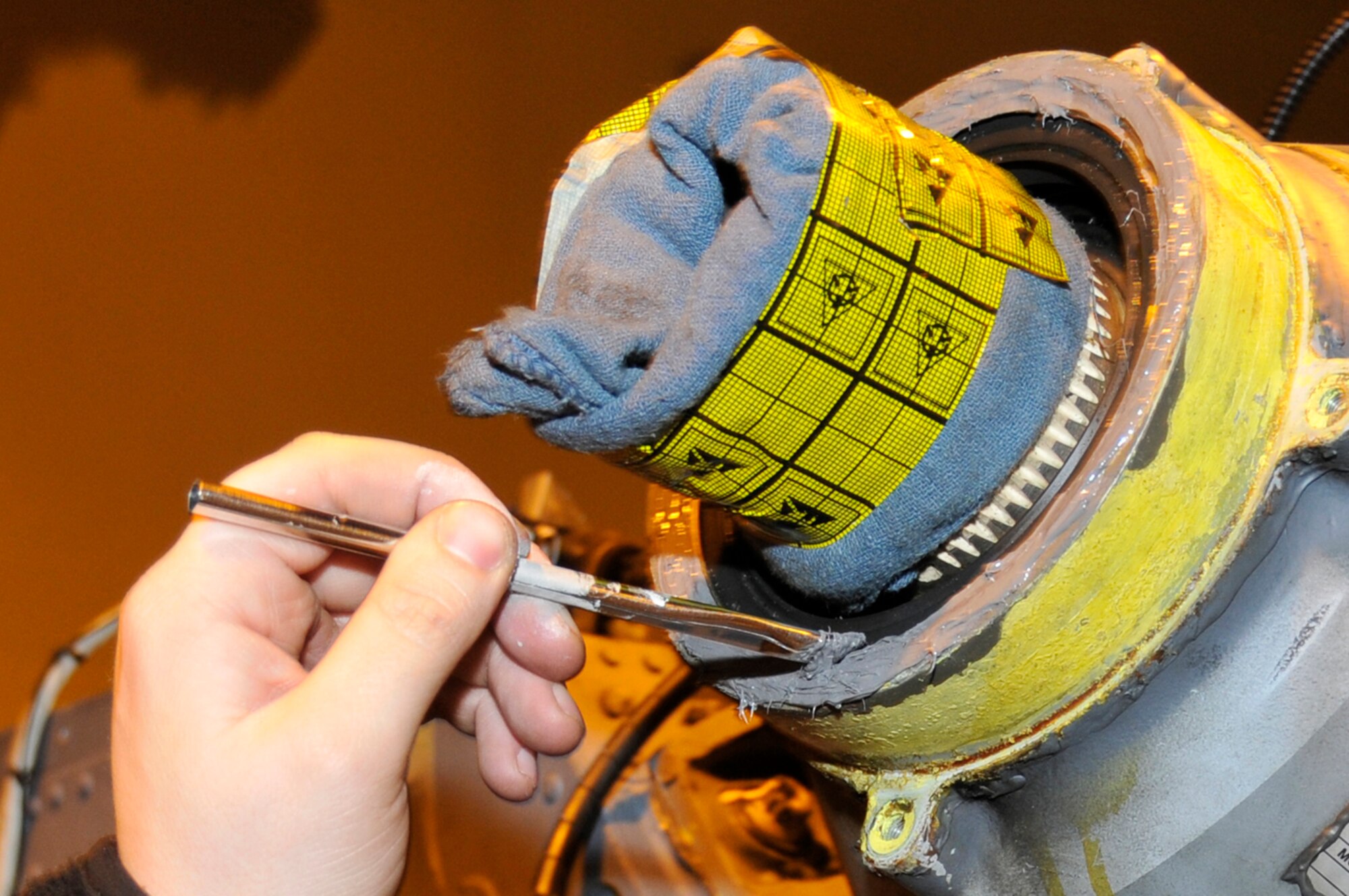 Staff Sgt. Seth Nehiley, 56 Aircraft Maintenance unit crew chief, uses a two-part sealant to seal an HH-60 Pave Hawk tail gear box's output seal, Jan. 27 at RAF Lakenheath, England. The sealant will help keep the fluid inside the gear box to prevent it from burning up when in flight. (U.S. Air Force photo by Airman 1st Class Perry Aston)