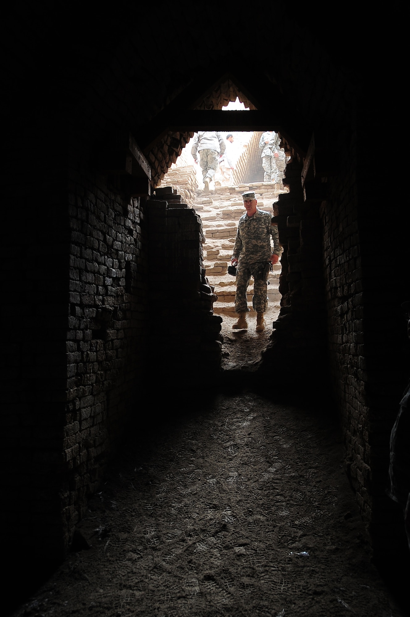 ALI BASE, Iraq – A Soldier looks into the dark ruins of a royal tomb Feb. 9, near the Great Ziggurat of Ur.  The tombs were built more than 4,000 years ago in the Sumerian city of Ur in ancient Mesopotamia, near present-day An Nasiriyah, Iraq.  Members of the 407th Air Expeditionary Group Chaplains Office offer three tours weekly of the Ziggurat and ruins of the city of Ur.  (U.S. Air Force photo/Staff Sgt. Christopher Marasky)