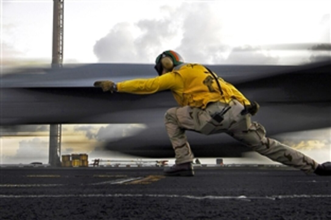 U.S. Navy Lt. Cmdr. Pete Salvaggio, flight deck launching officer, signals as an F/A-18E Super Hornet  takes off from the deck aboard the aircraft carrier USS John C. Stennis in the Pacific Ocean, Feb. 5, 2009.