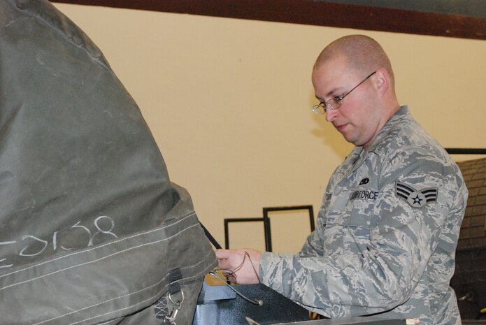Senior Airman Jeremy Deck, a 9th MXS Propulsion Flight journeyman, cinches down a strap after covering a U-2 engine Feb. 11. The flight is in charge of installing, removing and partial maintenance of more than 50 engines for the U-2 and Global Hawk aircraft.(Photo by Airman 1st Class Chuck Broadway)