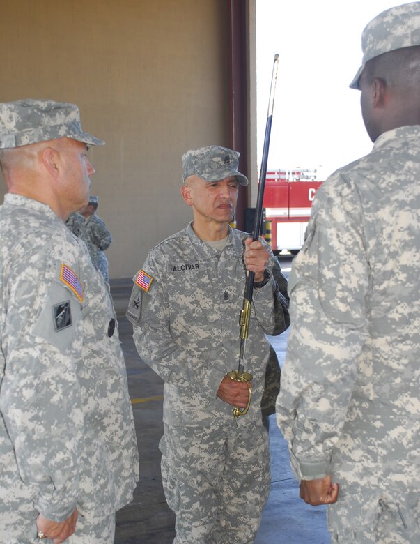 Command Sgt. Maj. Eloy Alcivar accepts the sword signifying his acceptance of responsibility as Joint Task Force-Bravo's top enlisted member at a Change of Responsibility ceremony Feb. 11 at the Soto Cano Air Base fire department. Sergeant Major Alcivar replaces Command Sgt. Maj. Timothy Mullins. (U.S. Air Force photo/Tech. Sgt. Rebecca Danet)