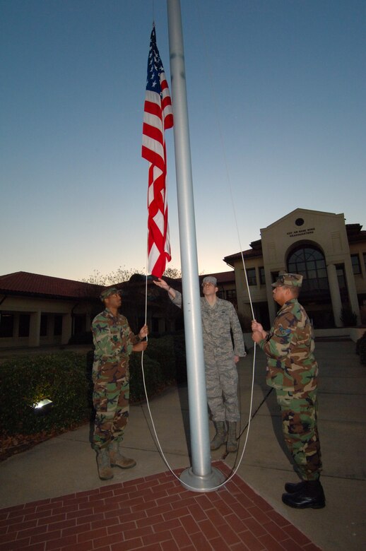 Shown in a retreat ceremony Jan. 29 from left are Senior Airman Yavine Brewer, Air University finance section; Senior Airman Jared Martin, Lemay Center; and Senior Airman Michael Hosea, 25th Aerial Port Squadron. As part of their training in military customs and courtesy, each class of Maxwell?s Airman Leadership School participates in the flag ceremony for Reveille and Retreat at 42nd Air Base Wing headquarters. (Air Force photo by Donna Burnett)