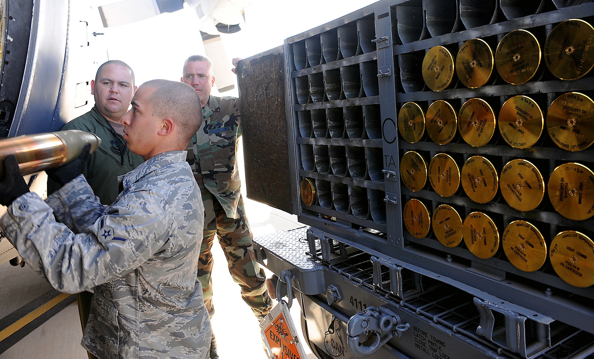 Amn. Frank Lauria hands a 105 mm cannon round to an aerial gunner inside a 16th Special Operations Squadron AC-130H Spectre gunship while training on the combat aircraft parking area at Cannon Air Force Base, N.M. Feb. 6. Airman Lauria and the munitions flight will be responsible for supplying live and training ammunition to special operations aircraft moving to the base. The Air Force Special Operations Training Center observed the loading procedures to help create a formal training program for use throughout Air Force Special Operations Command. Airman Lauria is assigned to the 27th Special Operations Equipment Maintenance Squadron Munitions Flight. (U.S. Air Force photo/Airman 1st Class Evelyn Chavez)