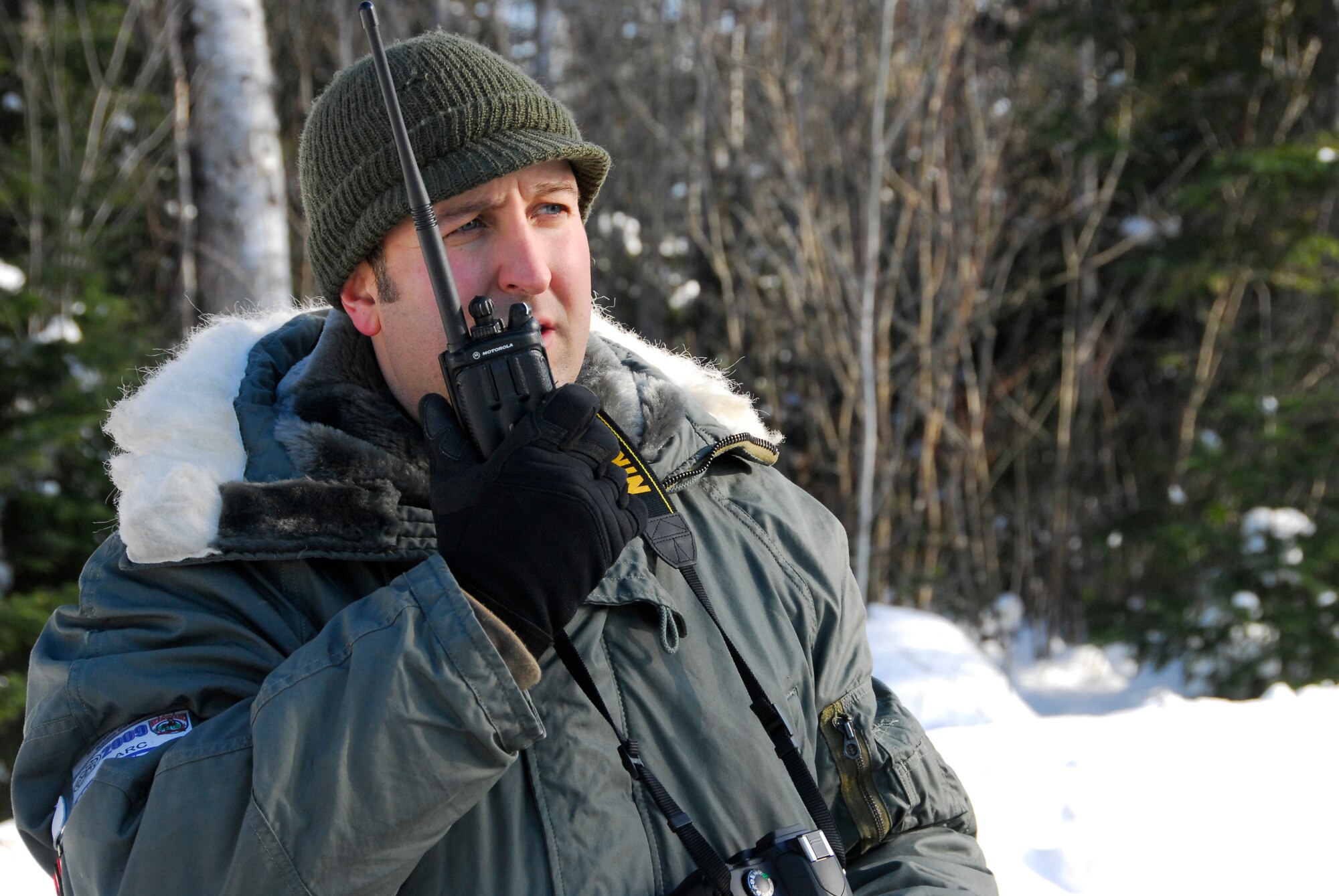 Air National Guard Master Sgt. Bryan Druar, 148th Fighter Wing communications specialist, radios information as a sled-dog team in the 26th running of the John Beargrease Sled-dog Marathon passes by January 27, 2009 at a remote trail crossing in Northern Minnesota.  The 148th Fighter Wing Communication Squadron provided communication support for the race while conducting training. 