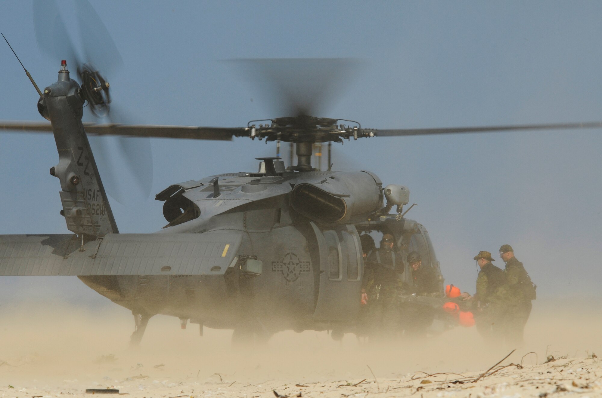 U.S. Air Force Pararescuemen and Japanese Air Self Defense Force (JASDF) Air Rescue personnel place a simulated survivor into an HH-60 Pave Hawk helicopter on a beach off the coast of Okinawa, Japan during exercise Cope Angel 09-1, Feb. 12, 2009. Cope Angel is a joint rescue exercise between members of the U.S. Air Force and the JASDF. (U.S. Air Force photo/Airman 1st Class Chad Warren)